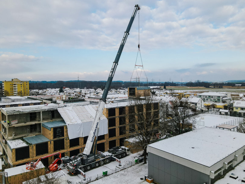 Liebherr LTM 1450-8.1 mobile crane couples timber modules with reinforced concrete carcass for care home